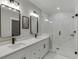 Modern bathroom features double vanity with framed mirrors and a glass enclosed shower with marble-patterned tiling at 2905 Ivy Mill Drive Dr, Buford, GA 30519