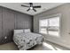 Bedroom features a bed with a patterned quilt and an accent wall with window overlooking the outside at 2905 Ivy Mill Drive Dr, Buford, GA 30519