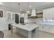 Modern kitchen with white cabinets, a large island, marble backsplash, and elegant pendant lighting at 2905 Ivy Mill Drive Dr, Buford, GA 30519