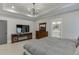 This main bedroom boasts a TV, fireplace, and a tray ceiling with recessed lighting and a stylish chandelier at 2905 Ivy Mill Drive Dr, Buford, GA 30519