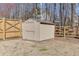 Backyard view of a well-kept vinyl storage shed with a wood fence and tidy lawn at 2905 Ivy Mill Drive Dr, Buford, GA 30519