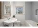 Bright bathroom featuring a gray tiled wall, modern fixtures, and a window offering natural light and outdoors view at 35 Adair Dr, Marietta, GA 30066