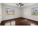 This bedroom features hardwood floors, two windows with views, white walls, and a black ceiling fan at 35 Adair Dr, Marietta, GA 30066