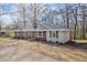 Side view of a brick home with a dark roof and mature trees, situated on a sloped lawn at 35 Adair Dr, Marietta, GA 30066