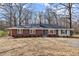 Charming brick home featuring a dark roof, chimney, and a well-maintained lawn surrounded by mature trees at 35 Adair Dr, Marietta, GA 30066