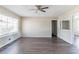 A neutral living room has a ceiling fan, grey wood floors, and a large window at 3651 Tulip Dr, Decatur, GA 30032