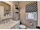 Stylish powder room with a marble vanity, decorative mirror, and patterned window shade at 370 Laurel Oak Dr, Suwanee, GA 30024