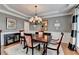 Elegant dining room featuring a chandelier, wainscoting and a dark wood table set for four at 370 Laurel Oak Dr, Suwanee, GA 30024