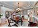 Formal dining room with wainscoting and a wooden table set for four under a chandelier at 370 Laurel Oak Dr, Suwanee, GA 30024