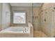 Bathroom boasting a soaking tub and walk-in shower with detailed tilework at 370 Laurel Oak Dr, Suwanee, GA 30024