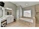 Bright bathroom with double vanity, a soaking tub, and tiled floors at 370 Laurel Oak Dr, Suwanee, GA 30024