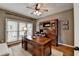 Home office with a large wooden desk, built-in shelves, and ample natural light from the windows at 370 Laurel Oak Dr, Suwanee, GA 30024