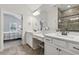 Bright bathroom featuring a white vanity, large mirrors, and shower with tile surround, with access to the main bedroom at 48 Lantern Trce, Hiram, GA 30141