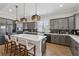 This kitchen features an island with countertop seating, stainless steel appliances, modern backsplash, and pendant lighting at 48 Lantern Trce, Hiram, GA 30141