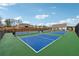 Multiple tennis courts with green and blue surfaces are adjacent to neighborhood homes and a covered pavilion at 48 Lantern Trce, Hiram, GA 30141