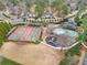 Aerial view of tennis courts, pool and playground in well-manicured suburban neighborhood at 708 Players Ct, Woodstock, GA 30189