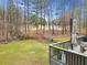 A fenced backyard shows a deck with furniture, grass lawn, and firepit at 708 Players Ct, Woodstock, GA 30189