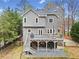 Backyard view featuring a spacious wooden deck with outdoor seating, overlooking lush greenery at 708 Players Ct, Woodstock, GA 30189