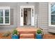 Front entrance featuring a blue door, brick steps, and welcoming landscaping at 708 Players Ct, Woodstock, GA 30189