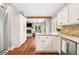 Modern kitchen with white cabinetry, stainless steel appliances, and an adjacent living and dining area at 708 Players Ct, Woodstock, GA 30189