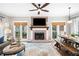 Inviting living room with a brick fireplace, a large television, and an adjacent dining area at 708 Players Ct, Woodstock, GA 30189