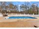 Large in-ground pool sits in a fenced yard with mature trees and an outdoor dining area at 3222 Bay View Dr, Jonesboro, GA 30236