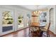 Sunlit dining room featuring hardwood floors, an elegant chandelier, and views of the well-manicured outdoor space at 5245 Emmett Still Rd, Loganville, GA 30052