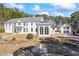 Traditional white facade featuring symmetrical windows and a portico entrance, with fire pit in the front yard at 5245 Emmett Still Rd, Loganville, GA 30052