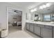 Elegant bathroom featuring a double vanity, sleek countertops, tile floors, and entry to bedroom at 167 Marlow Dr, Woodstock, GA 30188