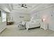 Spacious main bedroom with a tray ceiling, carpeted floor, and a cozy seating area at 167 Marlow Dr, Woodstock, GA 30188