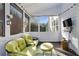 The enclosed porch has natural light from the many windows surrounding the comfortable seating at 167 Marlow Dr, Woodstock, GA 30188
