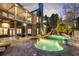 Stunning backyard at dusk featuring a pool with illuminated waterfalls and a covered patio with outdoor seating at 2146 Wolbert Trl, Marietta, GA 30062