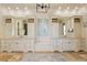 Bright bathroom featuring double vanities with custom cabinetry, decorative mirrors, and neutral stone flooring at 2146 Wolbert Trl, Marietta, GA 30062