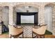 Indoor golf simulator featuring a high-definition screen, projector, brick archway, and comfortable seating at 2146 Wolbert Trl, Marietta, GA 30062
