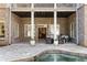 Covered patio with stone flooring, white columns, and outdoor seating, overlooking the pool and backyard at 2146 Wolbert Trl, Marietta, GA 30062