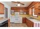 A well lit kitchen featuring wood cabinets, white appliances, vinyl floors, and generous counter space at 2804 Freemans Mill Rd, Dacula, GA 30019