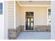 Inviting home entrance featuring a covered porch with brick accents at 7783 Hansel Ln, Lithonia, GA 30058