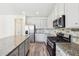 Bright kitchen features stainless steel appliances, granite countertops and tiled backsplash at 7783 Hansel Ln, Lithonia, GA 30058