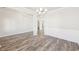 Spacious living area with laminate floors, elegant wainscotting, and a modern lighting fixture at 7783 Hansel Ln, Lithonia, GA 30058