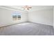 Spacious carpeted primary bedroom featuring a tray ceiling and large window at 7783 Hansel Ln, Lithonia, GA 30058