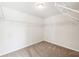 A walk-in closet with neutral walls and carpets has metal shelving with plenty of storage space at 7783 Hansel Ln, Lithonia, GA 30058
