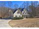 Side view of a yellow home with a covered porch, attached garage, and lush green landscaping at 596 Whitby Dr, Douglasville, GA 30134