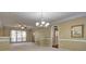 An open living room with carpet, chandelier, ceiling fan, and natural light streaming in from the large windows at 596 Whitby Dr, Douglasville, GA 30134