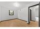 Bright bedroom featuring minimalist decor, a window with sheer curtains and light, wood-look vinyl flooring at 1172 Martin Nash Sw Rd, Lilburn, GA 30047