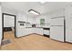 Well-lit kitchen with white cabinetry, modern appliances, and hardwood floors, offering a bright and functional cooking space at 1172 Martin Nash Sw Rd, Lilburn, GA 30047