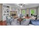 Inviting living room featuring a stone fireplace, built-in shelving, and windows providing natural light at 1870 Shoreline Trce, Grayson, GA 30017