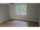 Cozy bedroom with neutral paint, hardwood floors, and a window for natural light at 1947 Kensington High Sw St, Lilburn, GA 30047