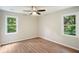 Bright bedroom with wood floors, ceiling fan and two windows offering ample natural light at 3333 Devaughn Ne Dr, Marietta, GA 30066