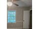 Bedroom features a fan with light fixture, closet, and bright window with natural light at 409 Arbor Ridge Dr, Stone Mountain, GA 30087