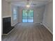 Open concept living room with deck access, fireplace, ceiling fan and vinyl floors at 409 Arbor Ridge Dr, Stone Mountain, GA 30087